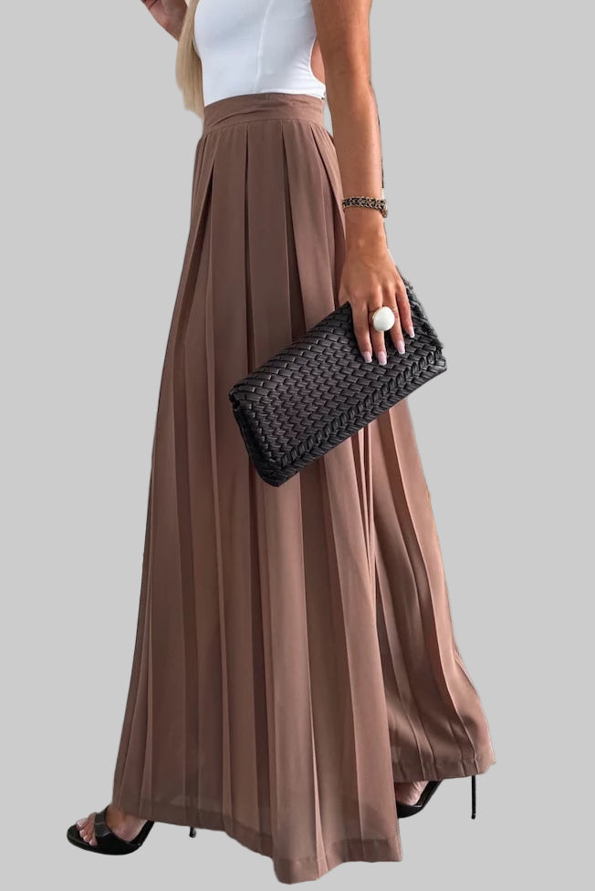 Woman in a white top and brown skirt standing in a clothing store.